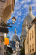 Sunny street and the domes of Sacre-Coeur in the morning, quarter Montmartre in Paris, France