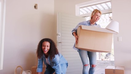 Canvas Print - Female Friends Carrying Boxes Into New Home And Celebrating On Moving Day