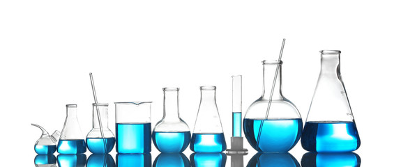 Laboratory glassware with liquid on table against color background. Chemical analysis