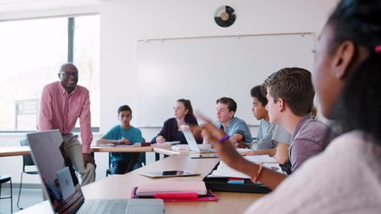 Wall Mural - Male High School Tutor Sitting On Desk And Asking Students Question