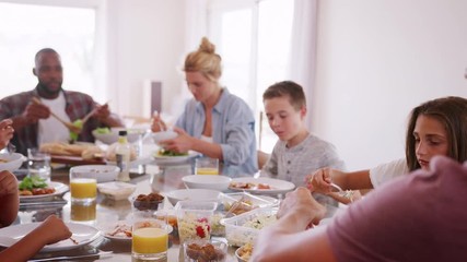 Wall Mural - Two Families Enjoying Meal At Home Together Shot In Slow Motion