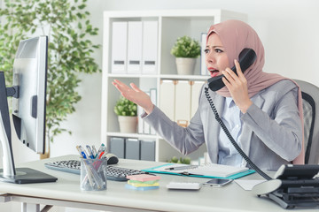 Wall Mural - Muslim businesswoman arguing by telephone