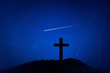Silhouette of crucifix cross on mountain at night time with star and space background.