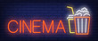 Cinema neon sign. Popcorn and coke on brick wall background. Vector illustration in neon style for movie watching and entertainment