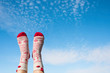 Woman's legs in the Christmas socks on the blue sky background. Winter Concept