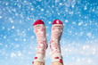 Woman's legs in the Christmas socks on the winter snowfall background. Concept
