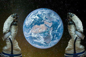 Wall Mural - caring for the planet. man in astronaut gloves holding the planet earth in the hands against the bac