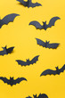 Halloween paper vampire bat decorations on an orange background.