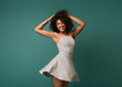 © Prostock-studio - Happy african-american woman dancing on turquoise background