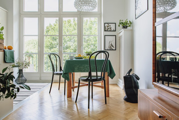 Wall Mural - Framed botanic posters on a white wall of a spacious dining room interior with glass door to the balcony and herringbone parquet floor