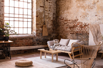 Wall Mural - Pouf and wooden table on carpet near window in wabi sabi interior with sofa and armchair. Real photo