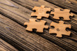 © gerasimov174 - Placing a piece of the puzzle on a textured old wooden table. Conceptual work in the team and cooperation. idea of business