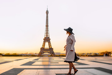 Wall Mural - Woman dressed in coat and hat walking on the famous square with great view on the Eiffel tower early in the morning in Paris