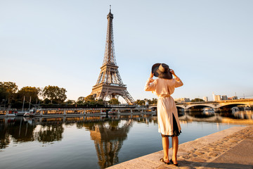 young woman tourist enjoying landscape view on the eiffel tower with beautiful reflection on the wat