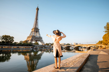 young woman tourist enjoying landscape view on the eiffel tower with beautiful reflection on the wat