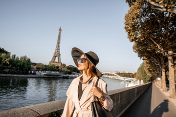 Young woman tourist walking on the riverside with beautiful landscape view on the Eiffel tower during the morning light in Paris