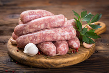 Raw Sausages On The Wooden Board