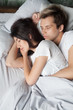 © fizkes - Young male and female in love sleeping and embracing in bed on bedroom at home. View from above. Couple resting at lazy weekend, free time, day nap or relaxation after working day concept. Top view