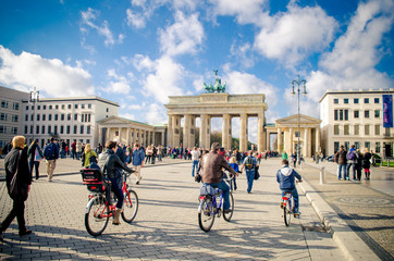 people cycling near brandenburg gate, berlin, germany