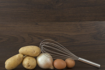 Wall Mural - potatoes, onion and egg on brown background