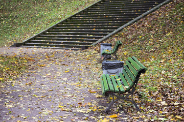 two green park benches and a long stone staircase in Gatchina Park in autumn.