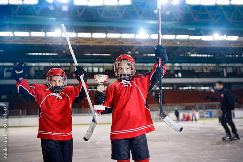 Fototapeta na szkło win the trophy in ice hockey- boys players team.