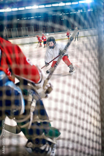 Fototapeta na szkło boy hockey players shoots the puck and attacks.