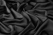 Black silk fabric background, view from above. Smooth elegant black silk or satin luxury cloth texture can use as abstract background with copy space, close-up 