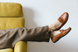 © JacquiMiller/Stocksy - Female wearing wool pants resting on vintage yellow sofa