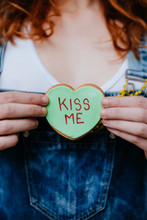 Woman Holding A Green 'kiss Me' Message Cookie