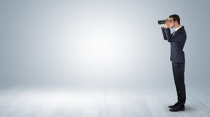 Wall Mural - businessman looking forward with binoculars in an empty space