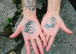 © kkgas/Stocksy - a tattoo of broken handcuffs on the palms of two hands