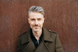 © guillefaingold/Stocksy - Handsome man in fashionable coat with grey hair.