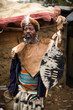 © JonnCarr/Stocksy - Traditional tribal African man dressed in animal skins and carrying a shield standing outside his homestead