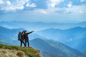 The happy couple gesturing on the cliff