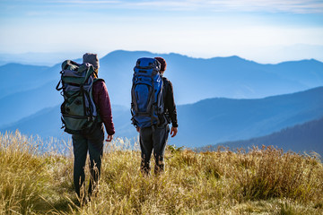 Wall Mural - the man and a woman standing on the mountain with a beautiful view