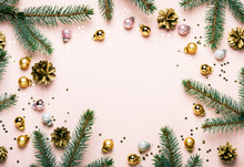 Pastel Pink Christmas Festive Frame Of Fir Branches, Golden Balls And Confetti