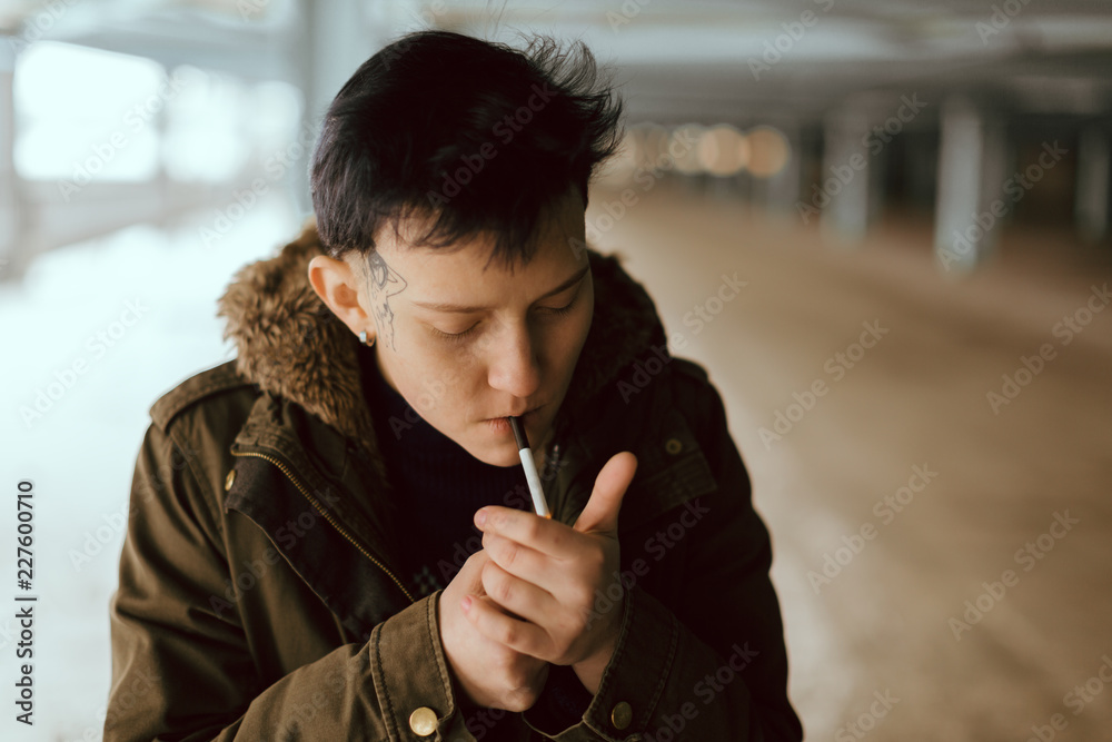 Real lesbian girl smoking on the parking area Stock Photo