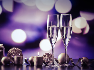 two champagne glasses against holiday lights and fireworks - new year celebration