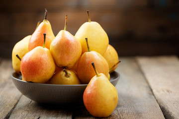 Wall Mural - Pears. Pears harvest. Fresh organic pears in plate on wooden table. Pear autumn harvest. Autumn concept.