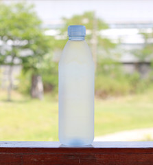 Cold drinking water in plastic bottle on green nature background