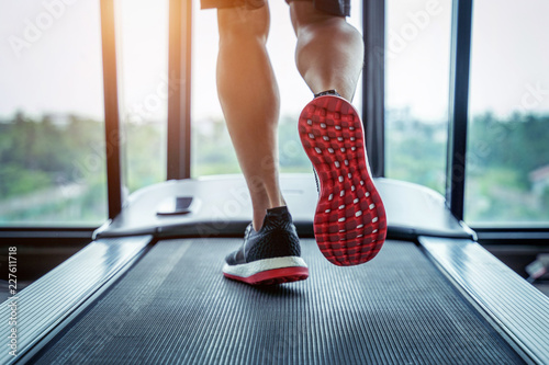 Cuadros en Lienzo Male feet in sneakers running on the treadmill at the gym