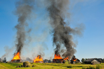 Burning village. Burning houses and see the black thick smoke.