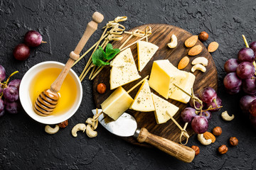 Poster - Cheese with grape and nuts on wooden board