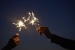 © adrian/Stocksy - Friends holding sparklers up to the night sky