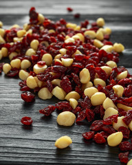 Wall Mural - Healthy snack of Dried cranberries and macadamia nuts in a ceramic bowl on rustic wooden table