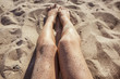 Woman legs on a sand beach