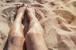 Woman legs on a sand beach, copy space