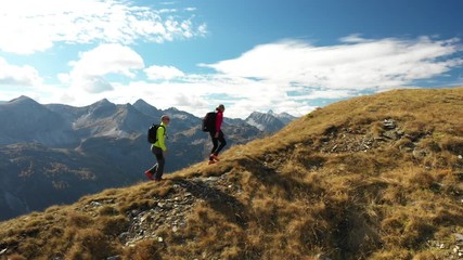 4k sport footage, aerial drone view active people couple hiking on mountain ridge on sunny day in au