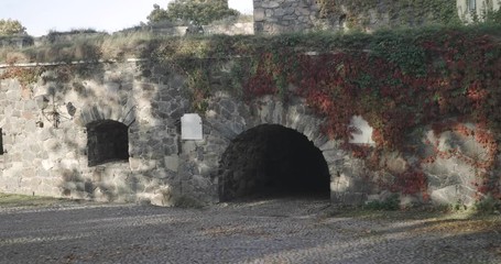 Wall Mural - Walking towards a passage to a medieval castle, a ancient fortress, on a cold autumn day, on Suomenlinna military island, in Helsinki, Uusimaa, Finland